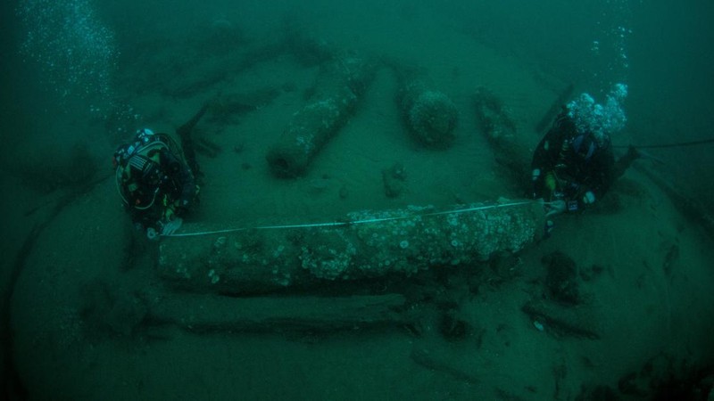 Brothers Julian Barnwell and Lincoln Barnwell measure a cannon underwater, from the shipwreck of HMS Gloucester, which sank 340 years ago while carrying King of England, James Stuart, and was discovered off the coast of Norfolk, Britain July 25, 2018. Norfolk Historic Shipwrecks/Handout via REUTERS    THIS IMAGE HAS BEEN SUPPLIED BY A THIRD PARTY. NO RESALES. NO ARCHIVES. MANDATORY CREDIT.