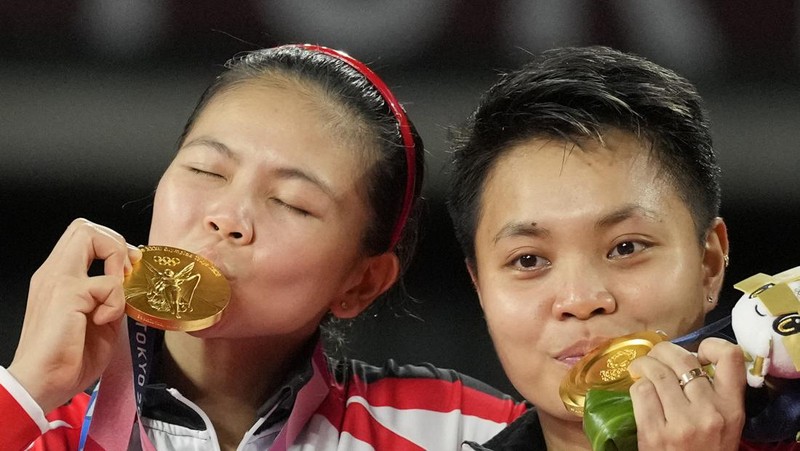 Indonesia's Greysia Polii, right, carries the Indonesian flag after defeating Germany's Brigit Overzier and Kathrin Piotrowski during their semi-final of the Uber Cup badminton championship match at Istora Senayan stadium in Jakarta, Indonesia, Thursday, May 15, 2008. (AP Photo/Firdia Lisnawati)