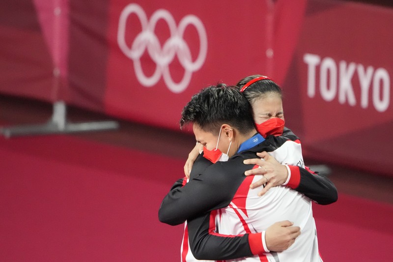 Indonesia's Greysia Polii, right, carries the Indonesian flag after defeating Germany's Brigit Overzier and Kathrin Piotrowski during their semi-final of the Uber Cup badminton championship match at Istora Senayan stadium in Jakarta, Indonesia, Thursday, May 15, 2008. (AP Photo/Firdia Lisnawati)