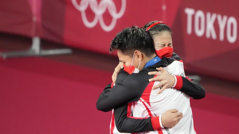 Indonesia's Greysia Polii, right, carries the Indonesian flag after defeating Germany's Brigit Overzier and Kathrin Piotrowski during their semi-final of the Uber Cup badminton championship match at Istora Senayan stadium in Jakarta, Indonesia, Thursday, May 15, 2008. (AP Photo/Firdia Lisnawati)