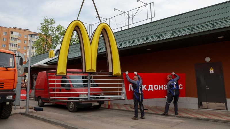 Workers use a crane to dismantle the McDonald's Golden Arches while removing the logo signage from a drive-through restaurant of McDonald's in the town of Kingisepp in the Leningrad region, Russia June 8, 2022. REUTERS/Anton Vaganov