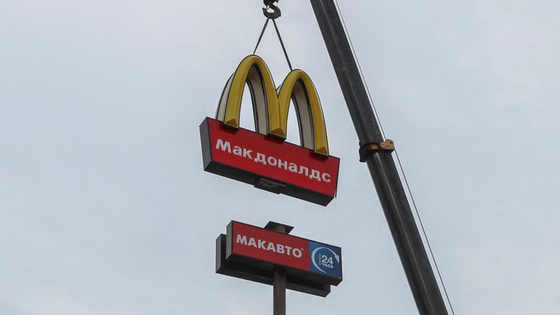 Workers use a crane to dismantle the McDonald's Golden Arches while removing the logo signage from a drive-through restaurant of McDonald's in the town of Kingisepp in the Leningrad region, Russia June 8, 2022. REUTERS/Anton Vaganov