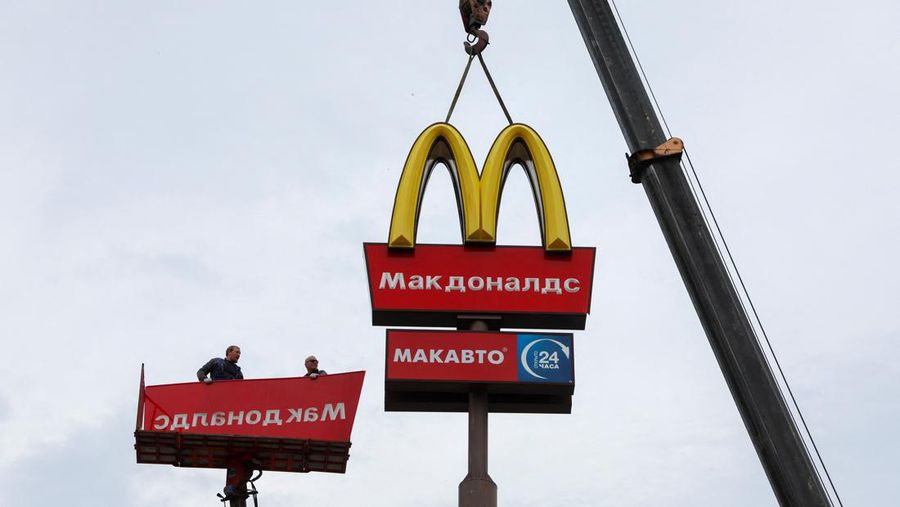 Workers use a crane to dismantle the McDonald's Golden Arches while removing the logo signage from a drive-through restaurant of McDonald's in the town of Kingisepp in the Leningrad region, Russia June 8, 2022. REUTERS/Anton Vaganov
