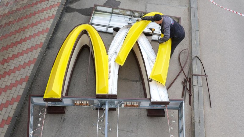 Workers use a crane to dismantle the McDonald's Golden Arches while removing the logo signage from a drive-through restaurant of McDonald's in the town of Kingisepp in the Leningrad region, Russia June 8, 2022. REUTERS/Anton Vaganov