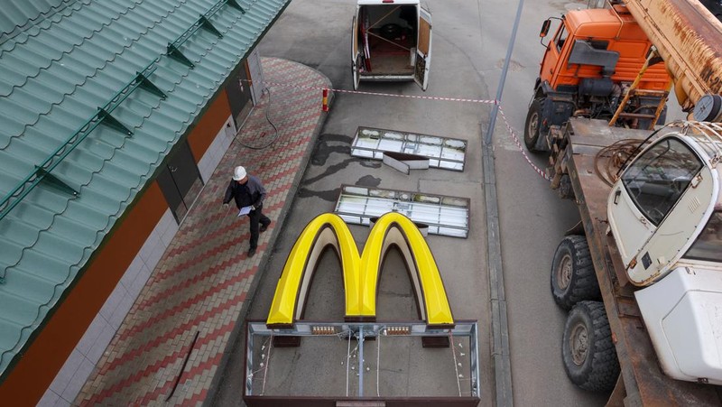 Workers use a crane to dismantle the McDonald's Golden Arches while removing the logo signage from a drive-through restaurant of McDonald's in the town of Kingisepp in the Leningrad region, Russia June 8, 2022. REUTERS/Anton Vaganov