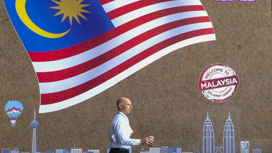 KUALA LUMPUR, MALAYSIA - 2018/01/24: A foreigner is seen with a Malaysia flag as a background.

Kuala Lumpur or commonly known as KL is the national capital for Malaysia and is the fastest growing metropolitan regions in South-East Asia. The urban city is also well known to the world for tourism and shopping. Kuala Lumpur has a great public transportation for people travel around the city. (Photo by Faris Hadziq/SOPA Images/LightRocket via Getty Images)