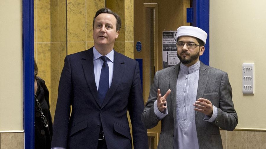 Perdana Menteri David Cameron (kiri) berbicara dengan Imam Qari Asim saat ia mengunjungi Masjid Masjid Makkah di Leeds , Inggris, Selasa (18/1/2022). (Photo by Oli Scarff - WPA Pool /Getty Images)
