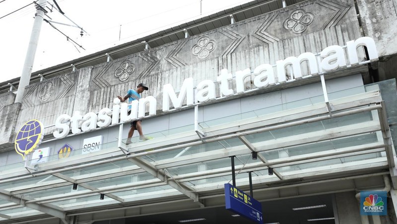Pekerja membersihkan papan nama Stasiun Matraman di Jakarta, Senin (13/6/2022). PT Kereta Commuter Indonesia (KCI) menyatakan Stasiun Matraman segera beroperasi sebagai alternatif shelter (CNBC Indonesia/ Tri Susilo)
