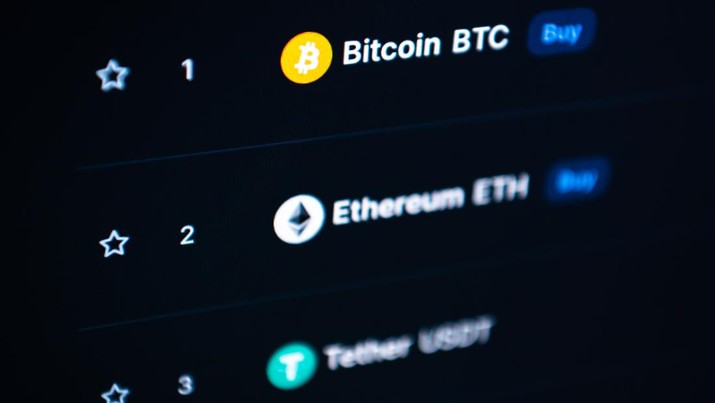 Logo mata uang kripto Bitcoin dan Ethereum terlihat di Coin Marketcap pada monitor komputer di kantor. (Photo by Silas Stein/picture alliance via Getty Images)