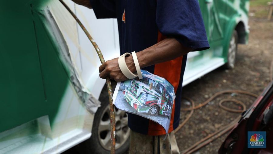 Pekerja menyelesaikan pembuatan mobil odong-odong di kawasan Pondok Aren, Tangerang Selatan, Banten, Selasa (14/6/2022). Di workshop ini mobil lama dan hanya menyisakan mesin beserta sasisnya lalu dirakit ulang menjadi kereta wisata mini atau yang biasa disebut dengan odong-odong. (CNBC Indonesia/ Tri Susilo)