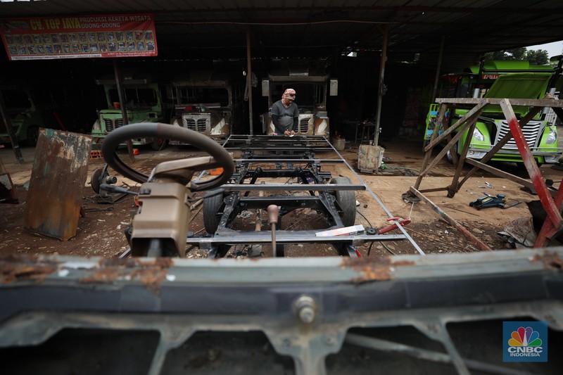 Pekerja menyelesaikan pembuatan mobil odong-odong di kawasan Pondok Aren, Tangerang Selatan, Banten, Selasa (14/6/2022). Di workshop ini mobil lama dan hanya menyisakan mesin beserta sasisnya lalu dirakit ulang menjadi kereta wisata mini atau yang biasa disebut dengan odong-odong. (CNBC Indonesia/ Tri Susilo)