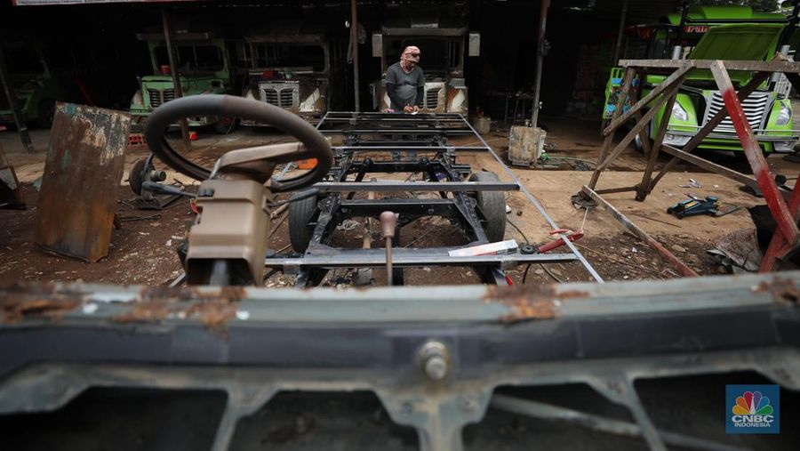 Pekerja menyelesaikan pembuatan mobil odong-odong di kawasan Pondok Aren, Tangerang Selatan, Banten, Selasa (14/6/2022). Di workshop ini mobil lama dan hanya menyisakan mesin beserta sasisnya lalu dirakit ulang menjadi kereta wisata mini atau yang biasa disebut dengan odong-odong. (CNBC Indonesia/ Tri Susilo)