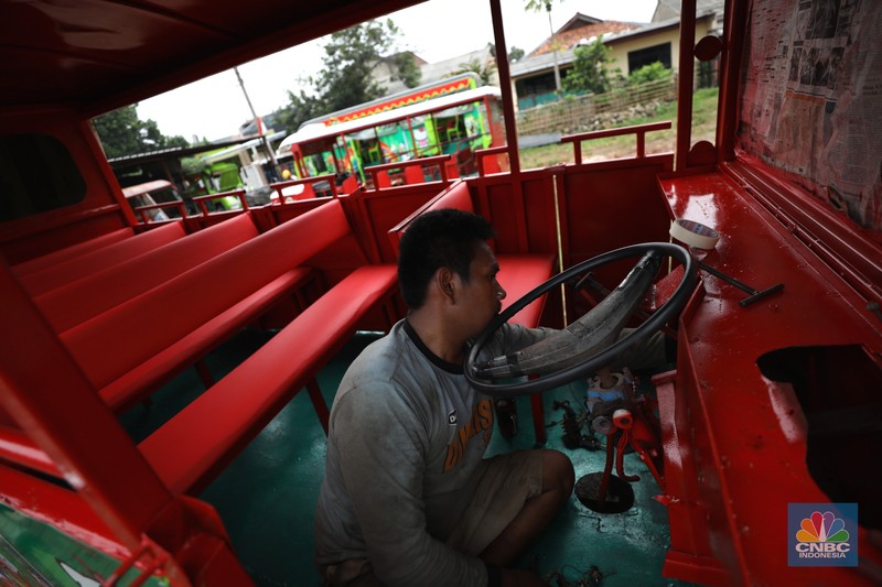 Pekerja menyelesaikan pembuatan mobil odong-odong di kawasan Pondok Aren, Tangerang Selatan, Banten, Selasa (14/6/2022). Di workshop ini mobil lama dan hanya menyisakan mesin beserta sasisnya lalu dirakit ulang menjadi kereta wisata mini atau yang biasa disebut dengan odong-odong. (CNBC Indonesia/ Tri Susilo)