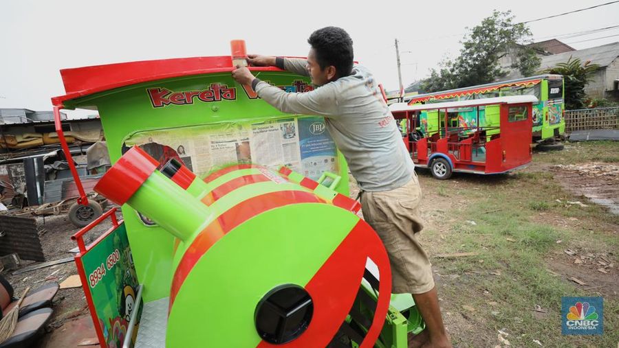 Pekerja menyelesaikan pembuatan mobil odong-odong di kawasan Pondok Aren, Tangerang Selatan, Banten, Selasa (14/6/2022). Di workshop ini mobil lama dan hanya menyisakan mesin beserta sasisnya lalu dirakit ulang menjadi kereta wisata mini atau yang biasa disebut dengan odong-odong. (CNBC Indonesia/ Tri Susilo)