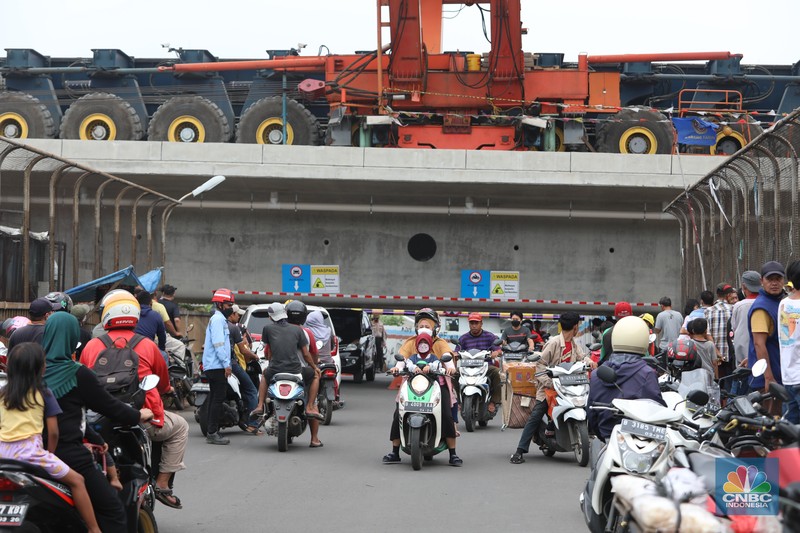 Penampakan Girder Jalur Kereta Cepat Halangi Jalanan di Jembatan Antelope, Curug, Bekasi, Petugas mengatur lalu lintas kendaraan yang melintas di Jembatan Antelope, Curug, Bekasi, Jawa Barat, Selasa (14/6/2022). Pengaturan lalu lintas karena adanya pemasangan girder proyek kereta cepat dan hanya dapat dilalui kendaraan dengan ketinggian maksimal 1,7 meter dari tanggal 13 Juni hingga 10 Agustus 2022. (CNBC Indonesia/ Muhammad Sabki)