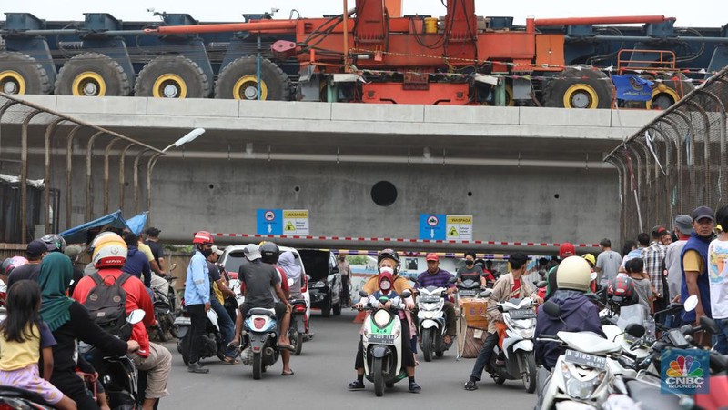Petugas mengatur lalu lintas kendaraan yang melintas di Jembatan Antelope, Curug, Bekasi, Jawa Barat, Selasa (14/6/2022). Pengaturan lalu lintas karena adanya pemasangan girder proyek kereta cepat dan hanya dapat dilalui kendaraan dengan ketinggian maksimal 1,7 meter dari tanggal 13 Juni hingga 10 Agustus 2022. (CNBC Indonesia/ Muhammad Sabki)