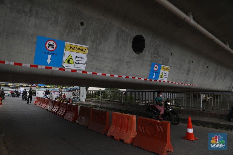 Petugas mengatur lalu lintas kendaraan yang melintas di Jembatan Antelope, Curug, Bekasi, Jawa Barat, Selasa (14/6/2022). Pengaturan lalu lintas karena adanya pemasangan girder proyek kereta cepat dan hanya dapat dilalui kendaraan dengan ketinggian maksimal 1,7 meter dari tanggal 13 Juni hingga 10 Agustus 2022. (CNBC Indonesia/ Muhammad Sabki)