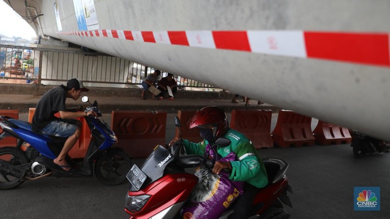 Petugas mengatur lalu lintas kendaraan yang melintas di Jembatan Antelope, Curug, Bekasi, Jawa Barat, Selasa (14/6/2022). Pengaturan lalu lintas karena adanya pemasangan girder proyek kereta cepat dan hanya dapat dilalui kendaraan dengan ketinggian maksimal 1,7 meter dari tanggal 13 Juni hingga 10 Agustus 2022. (CNBC Indonesia/ Muhammad Sabki)