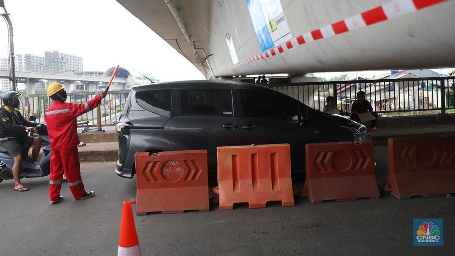 Petugas mengatur lalu lintas kendaraan yang melintas di Jembatan Antelope, Curug, Bekasi, Jawa Barat, Selasa (14/6/2022). Pengaturan lalu lintas karena adanya pemasangan girder proyek kereta cepat dan hanya dapat dilalui kendaraan dengan ketinggian maksimal 1,7 meter dari tanggal 13 Juni hingga 10 Agustus 2022. (CNBC Indonesia/ Muhammad Sabki)