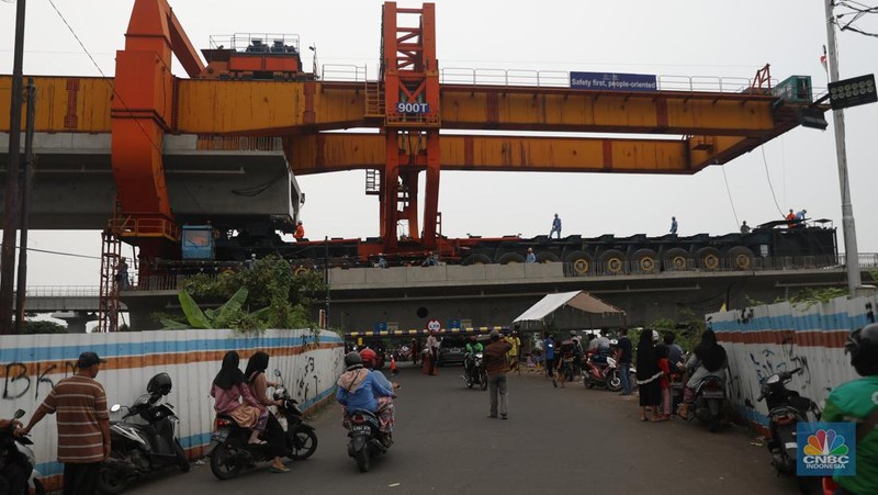 Petugas mengatur lalu lintas kendaraan yang melintas di Jembatan Antelope, Curug, Bekasi, Jawa Barat, Selasa (14/6/2022). Pengaturan lalu lintas karena adanya pemasangan girder proyek kereta cepat dan hanya dapat dilalui kendaraan dengan ketinggian maksimal 1,7 meter dari tanggal 13 Juni hingga 10 Agustus 2022. (CNBC Indonesia/ Muhammad Sabki)