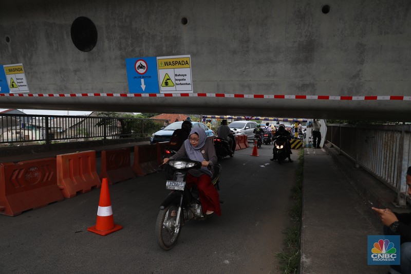 Petugas mengatur lalu lintas kendaraan yang melintas di Jembatan Antelope, Curug, Bekasi, Jawa Barat, Selasa (14/6/2022). Pengaturan lalu lintas karena adanya pemasangan girder proyek kereta cepat dan hanya dapat dilalui kendaraan dengan ketinggian maksimal 1,7 meter dari tanggal 13 Juni hingga 10 Agustus 2022. (CNBC Indonesia/ Muhammad Sabki)