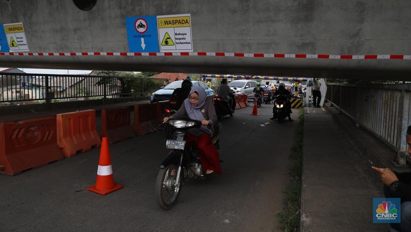 Petugas mengatur lalu lintas kendaraan yang melintas di Jembatan Antelope, Curug, Bekasi, Jawa Barat, Selasa (14/6/2022). Pengaturan lalu lintas karena adanya pemasangan girder proyek kereta cepat dan hanya dapat dilalui kendaraan dengan ketinggian maksimal 1,7 meter dari tanggal 13 Juni hingga 10 Agustus 2022. (CNBC Indonesia/ Muhammad Sabki)