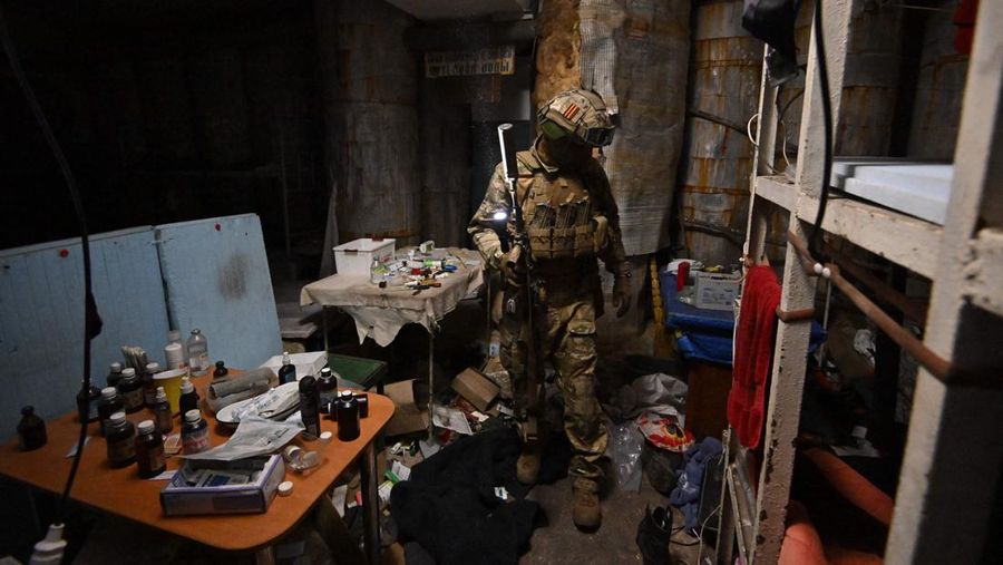 Seorang prajurit Rusia memeriksa tempat perlindungan bawah tanah di pabrik baja Azovstal di Mariupol, di tengah aksi militer Rusia yang sedang berlangsung di Ukraina, Senin (13/6/2022). (Photo by YURI KADOBNOV/AFP via Getty Images)