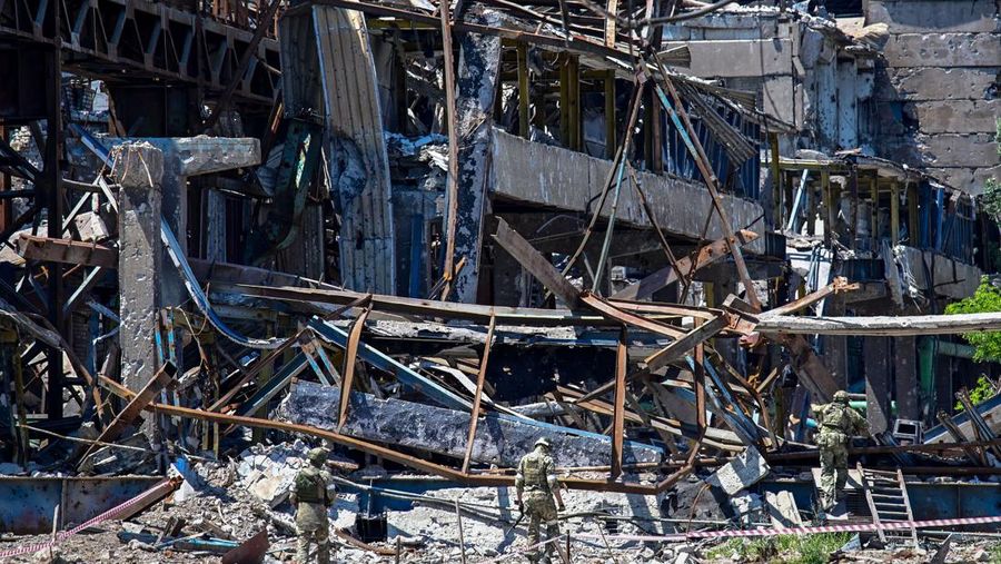 Prajurit Rusia berpatroli di dekat pabrik baja Azovstal di Mariupol, di tengah aksi militer Rusia yang sedang berlangsung di Ukraina, Senin (13/6/2022). (Photo by YURI KADOBNOV/AFP via Getty Images)