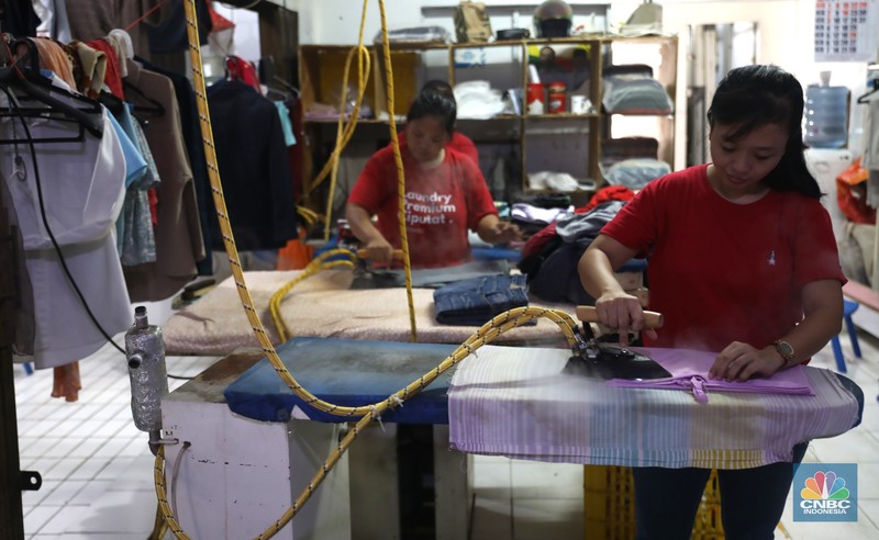 Usaha laundry Pekerja menyelesaikan pekerjaannya di jasa cuci setrika Laundry di Kawasan Tangerang Selatan, Banten, Selasa (14/6/2022). (CNBC Indonesia/ Muhammad Sabki)