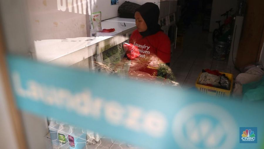 Pekerja menyelesaikan pekerjaannya di jasa cuci setrika Laundry di Kawasan Tangerang Selatan, Banten, Selasa (14/6/2022). (CNBC Indonesia/ Muhammad Sabki)