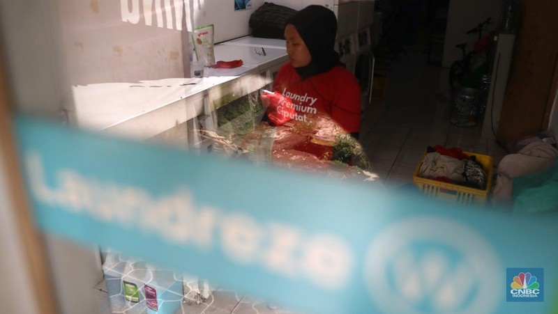 Pekerja menyelesaikan pekerjaannya di jasa cuci setrika Laundry di Kawasan Tangerang Selatan, Banten, Selasa (14/6/2022). (CNBC Indonesia/ Muhammad Sabki)