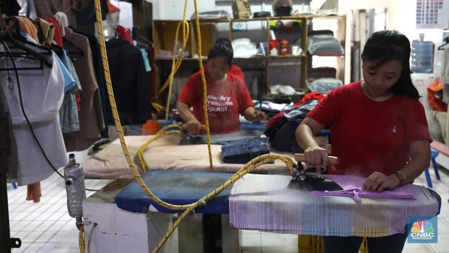 Pekerja menyelesaikan pekerjaannya di jasa cuci setrika Laundry di Kawasan Tangerang Selatan, Banten, Selasa (14/6/2022). (CNBC Indonesia/ Muhammad Sabki)