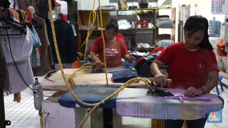 Pekerja menyelesaikan pekerjaannya di jasa cuci setrika Laundry di Kawasan Tangerang Selatan, Banten, Selasa (14/6/2022). (CNBC Indonesia/ Muhammad Sabki)