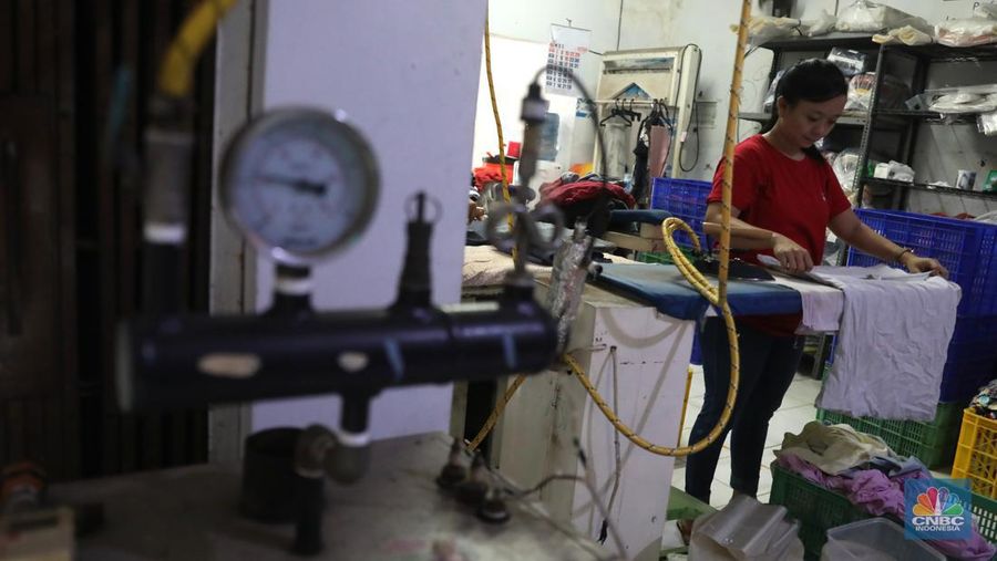 Pekerja menyelesaikan pekerjaannya di jasa cuci setrika Laundry di Kawasan Tangerang Selatan, Banten, Selasa (14/6/2022). (CNBC Indonesia/ Muhammad Sabki)
