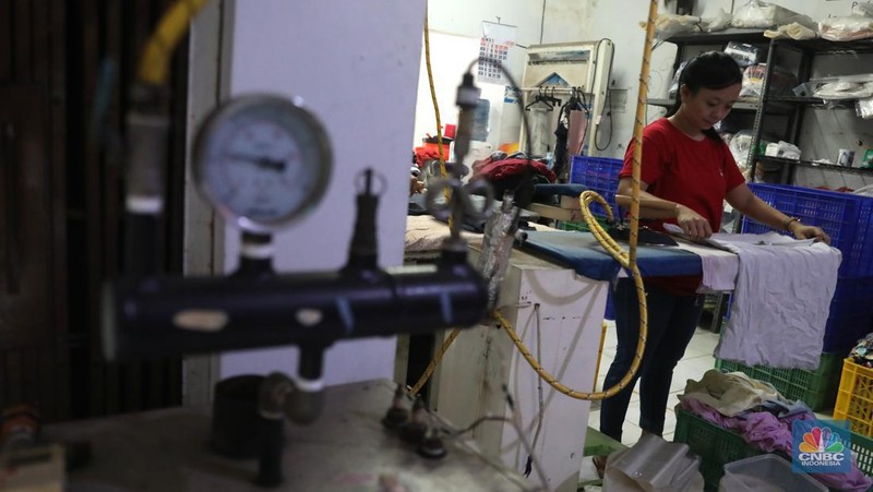 Pekerja menyelesaikan pekerjaannya di jasa cuci setrika Laundry di Kawasan Tangerang Selatan, Banten, Selasa (14/6/2022). (CNBC Indonesia/ Muhammad Sabki)