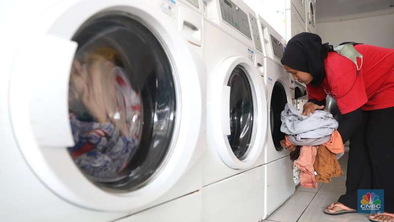 Pekerja menyelesaikan pekerjaannya di jasa cuci setrika Laundry di Kawasan Tangerang Selatan, Banten, Selasa (14/6/2022). (CNBC Indonesia/ Muhammad Sabki)