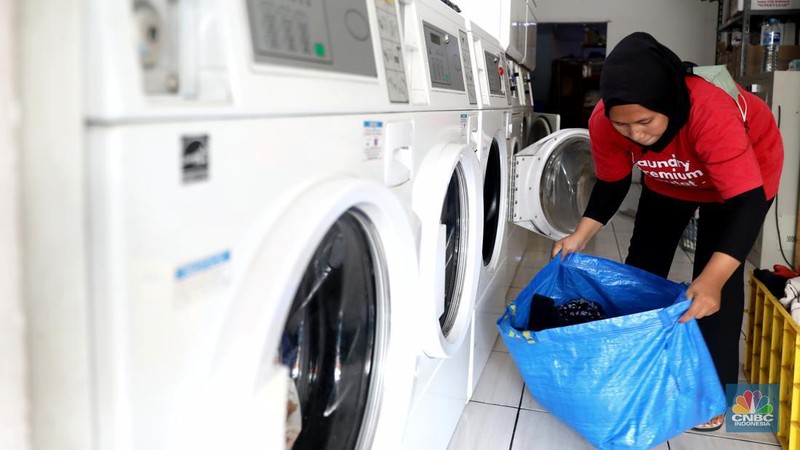 Pekerja menyelesaikan pekerjaannya di jasa cuci setrika Laundry di Kawasan Tangerang Selatan, Banten, Selasa (14/6/2022). (CNBC Indonesia/ Muhammad Sabki)