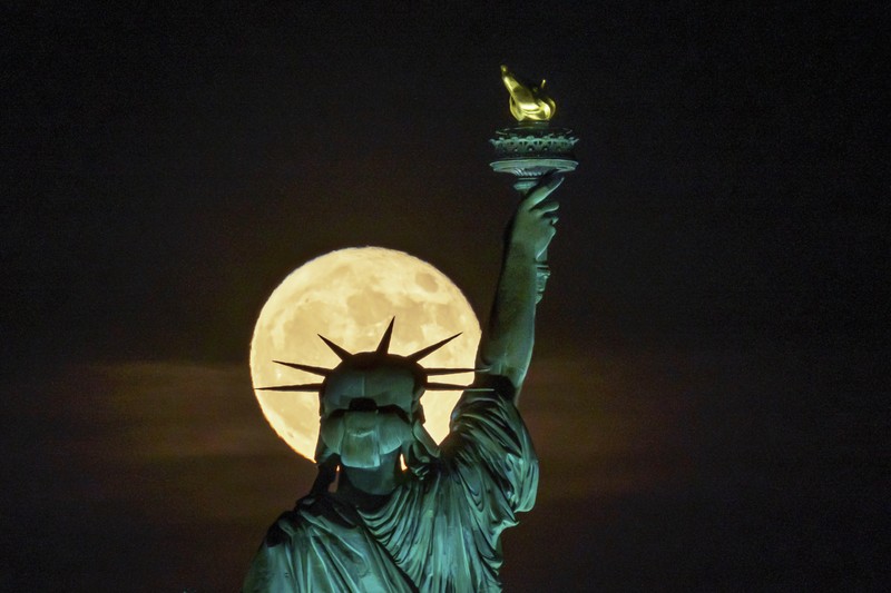 Supermoon bulan purnama stroberi di depan Patung Liberty di New York Bulan purnama yang dikenal sebagai
