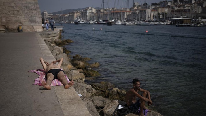 Orang-orang berjemur saat gelombang panas di Marseille, Prancis selatan, Rabu (15/6/2022). (AP Photo/Daniel Cole)