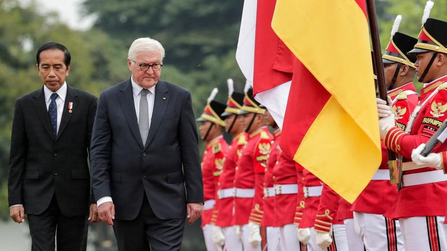 Presiden Jerman Frank-Walter Steinmeier dan Presiden Indonesia Joko Widodo berjalan saat mereka memeriksa para pengawal kehormatan selama upacara penyambutan menjelang pertemuan mereka di Istana Kepresidenan di Bogor, Kamis (16/6/2022). (Mast Irham/Pool via REUTERS)