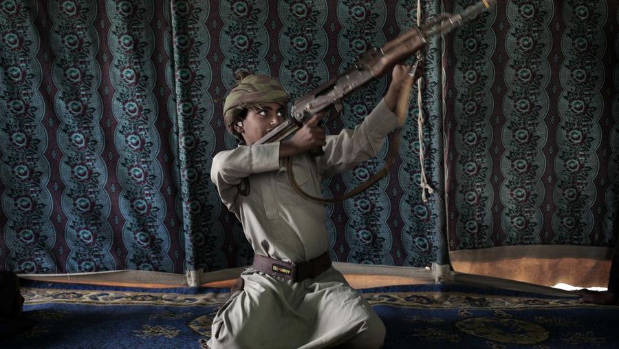 Kahlan, seorang mantan tentara anak berusia 12 tahun, mendemonstrasikan cara menggunakan senjata, di sebuah kamp untuk orang-orang terlantar tempat dia berlindung bersama keluarganya, di Marib, Yaman, Jumat (27/7/2018). Pemberontak Houthi terus berlanjut merekrut anak-anak ke dalam barisan militer mereka untuk berperang dalam perang saudara negara itu, meskipun ada kesepakatan dengan PBB pada April 2022, untuk menghentikan praktik tersebut. (AP Photo/Nariman El-Mofty