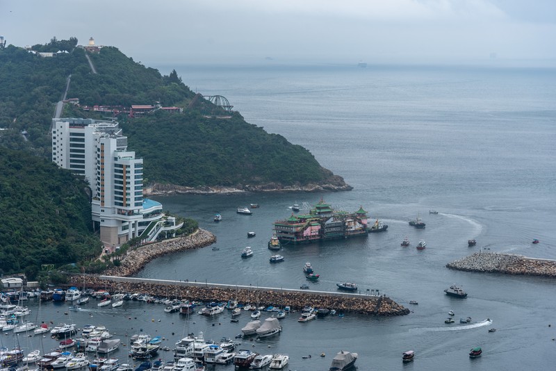 Turis mengambil foto di depan Restoran Terapung Jumbo bergaya kekaisaran China di Aberdeen, Hong Kong, Senin (13/6/2022). Restoran Terapung Jumbo yang ikonik di Hong Kong akan meninggalkan kota, di tengah kurangnya dana untuk memelihara restoran setelah berbulan-bulan pembatasan COVID-19. (Photo by Anthony Kwan/Getty Images)