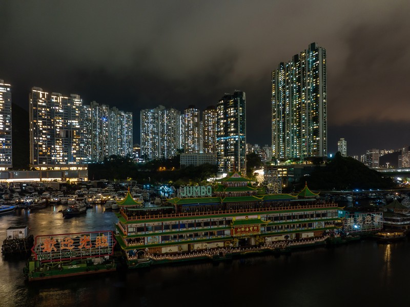 Turis mengambil foto di depan Restoran Terapung Jumbo bergaya kekaisaran China di Aberdeen, Hong Kong, Senin (13/6/2022). Restoran Terapung Jumbo yang ikonik di Hong Kong akan meninggalkan kota, di tengah kurangnya dana untuk memelihara restoran setelah berbulan-bulan pembatasan COVID-19. (Photo by Anthony Kwan/Getty Images)