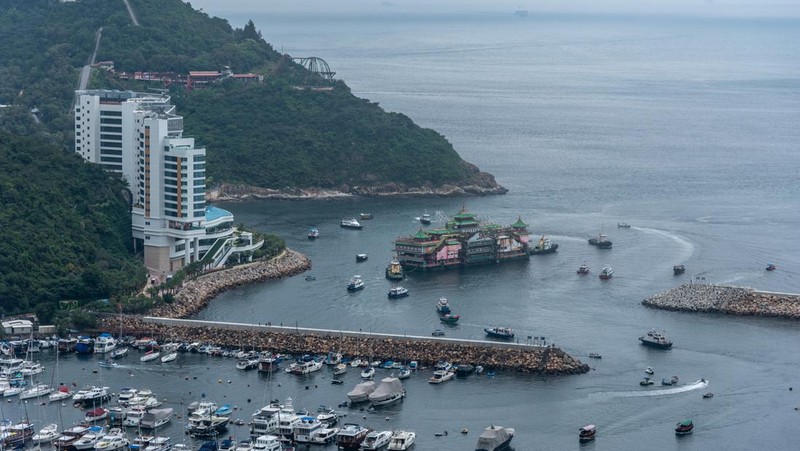 Turis mengambil foto di depan Restoran Terapung Jumbo bergaya kekaisaran China di Aberdeen, Hong Kong, Senin (13/6/2022). Restoran Terapung Jumbo yang ikonik di Hong Kong akan meninggalkan kota, di tengah kurangnya dana untuk memelihara restoran setelah berbulan-bulan pembatasan COVID-19. (Photo by Anthony Kwan/Getty Images)