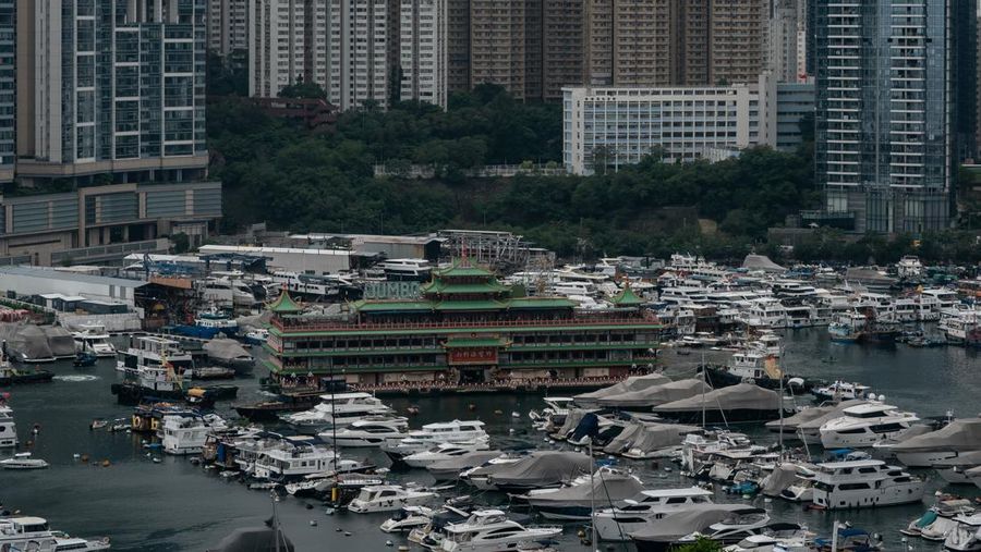 Turis mengambil foto di depan Restoran Terapung Jumbo bergaya kekaisaran China di Aberdeen, Hong Kong, Senin (13/6/2022). Restoran Terapung Jumbo yang ikonik di Hong Kong akan meninggalkan kota, di tengah kurangnya dana untuk memelihara restoran setelah berbulan-bulan pembatasan COVID-19. (Photo by Anthony Kwan/Getty Images)