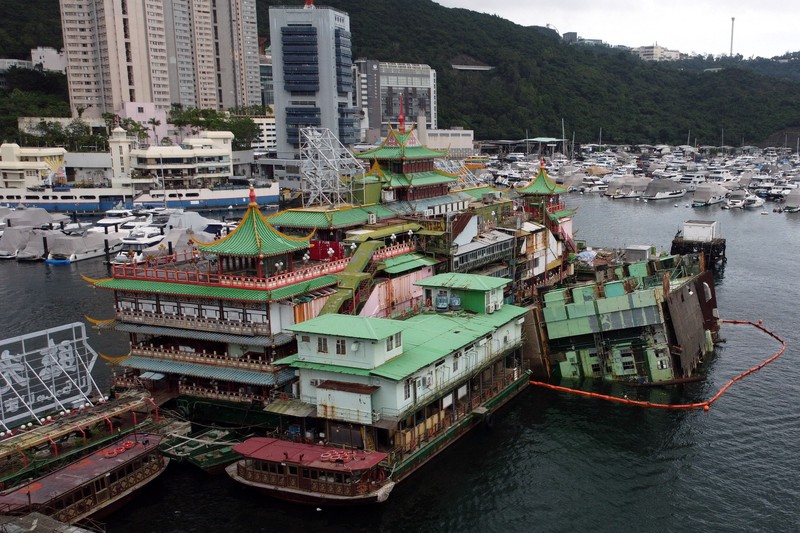 Turis mengambil foto di depan Restoran Terapung Jumbo bergaya kekaisaran China di Aberdeen, Hong Kong, Senin (13/6/2022). Restoran Terapung Jumbo yang ikonik di Hong Kong akan meninggalkan kota, di tengah kurangnya dana untuk memelihara restoran setelah berbulan-bulan pembatasan COVID-19. (Photo by Anthony Kwan/Getty Images)