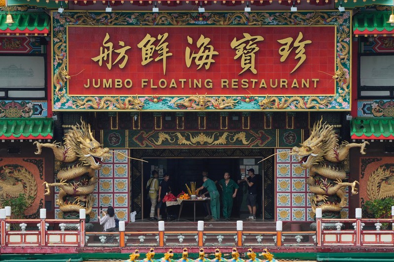 Turis mengambil foto di depan Restoran Terapung Jumbo bergaya kekaisaran China di Aberdeen, Hong Kong, Senin (13/6/2022). Restoran Terapung Jumbo yang ikonik di Hong Kong akan meninggalkan kota, di tengah kurangnya dana untuk memelihara restoran setelah berbulan-bulan pembatasan COVID-19. (Photo by Anthony Kwan/Getty Images)