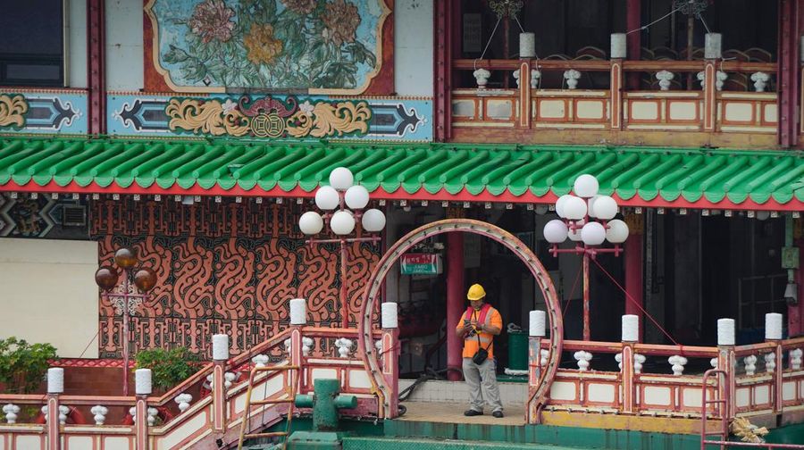 Turis mengambil foto di depan Restoran Terapung Jumbo bergaya kekaisaran China di Aberdeen, Hong Kong, Senin (13/6/2022). Restoran Terapung Jumbo yang ikonik di Hong Kong akan meninggalkan kota, di tengah kurangnya dana untuk memelihara restoran setelah berbulan-bulan pembatasan COVID-19. (Photo by Anthony Kwan/Getty Images)