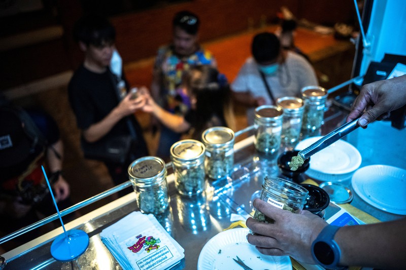 Turis mengantre untuk membeli ganja, setelah dihapus dari daftar narkotika di bawah hukum Thailand, di Happy Bud, sebuah truk ganja di Khaosan Road, Bangkok, ThailandSenin (13/6/2022). (REUTERS/Athit Perawongmetha)