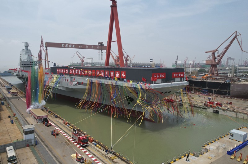 kapal induk ketiga China bernama Fujian Asap berwarna menandai upacara peluncuran kapal induk ketiga China bernama Fujian di dok kering di Shanghai, Jumat (17/6/2022) Media pemerintah melaporkan bahwa China pada hari Jumat meluncurkan kapal induk ketiganya, kapal pertama yang dirancang dan dibangun seluruhnya di dalam negeri. (Li Gang/Xinhua via AP)